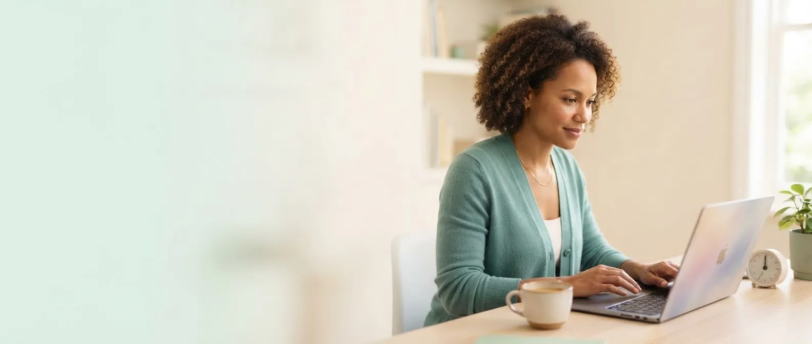 A woman learning at her laptop with a cup of coffee