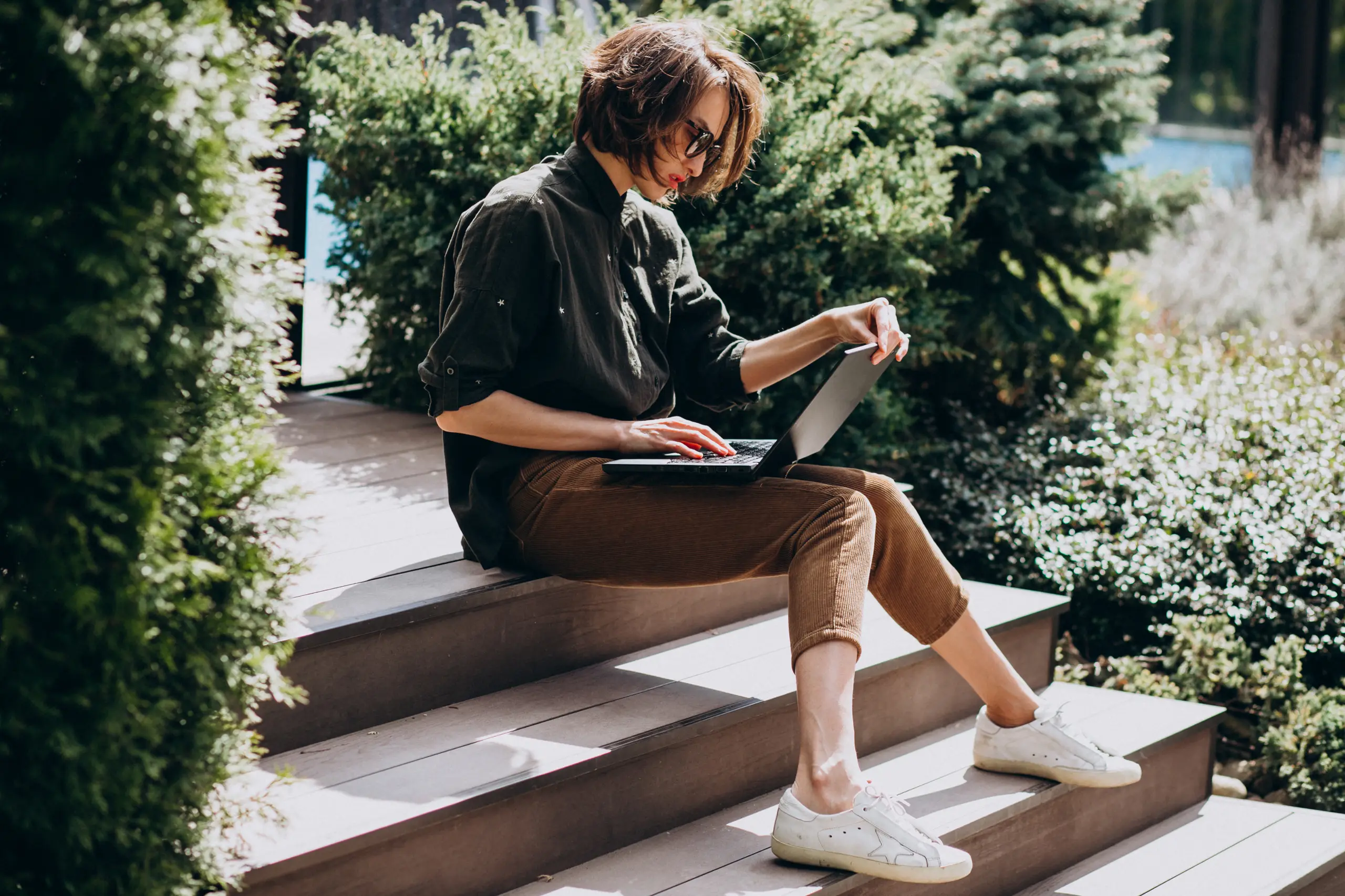 A learner on garden steps working through a course on her laptop